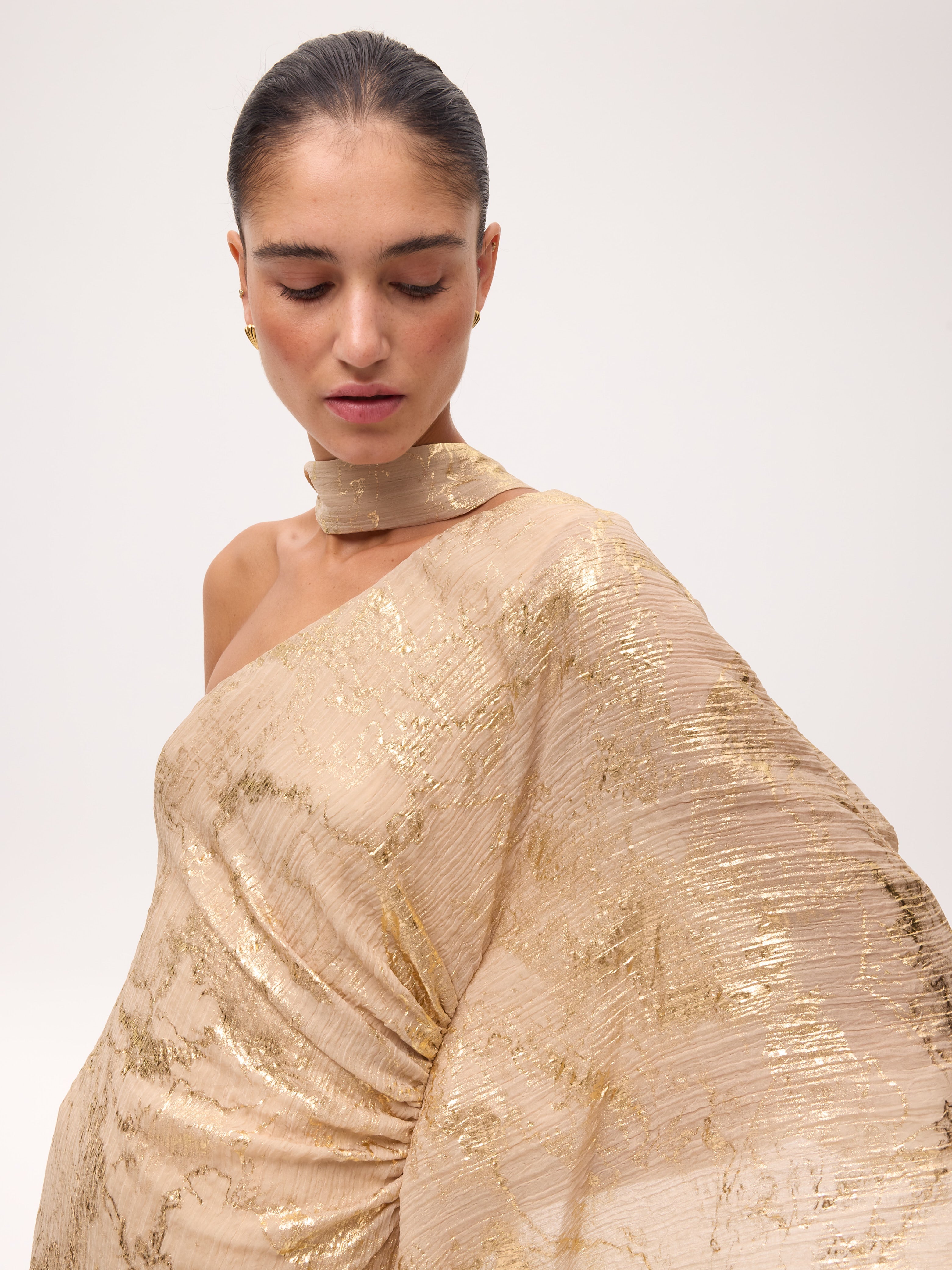 AARON - Vestido asimétrico manga capa nude con lurex, perfecto para invitadas de boda y fiesta spring summer. MIOH es la marca de vestidos de invitada de boda y fiesta de referencia en España